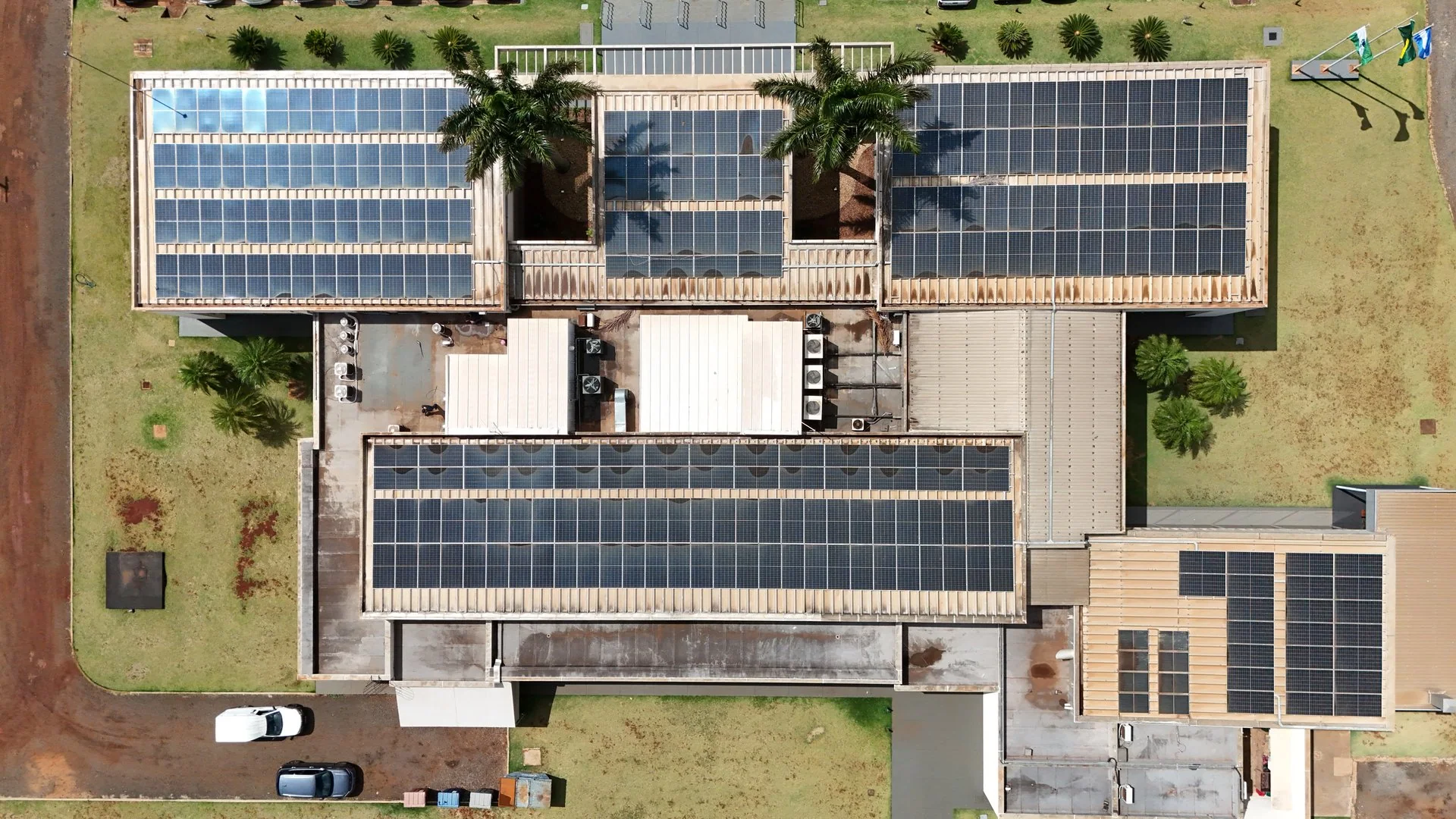 Vista aérea de planta industrial com painéis solares cobrindo todo o telhado